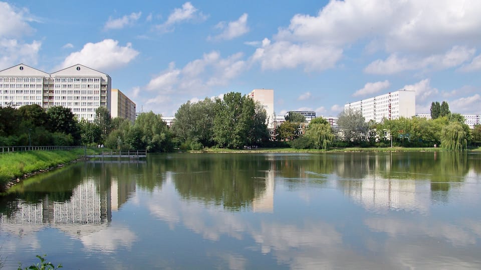 Der Silbersee in Leipzig, dahinter die Plattenbau-Silhouette des Stadtteils Lößnig im Süden der Stadt