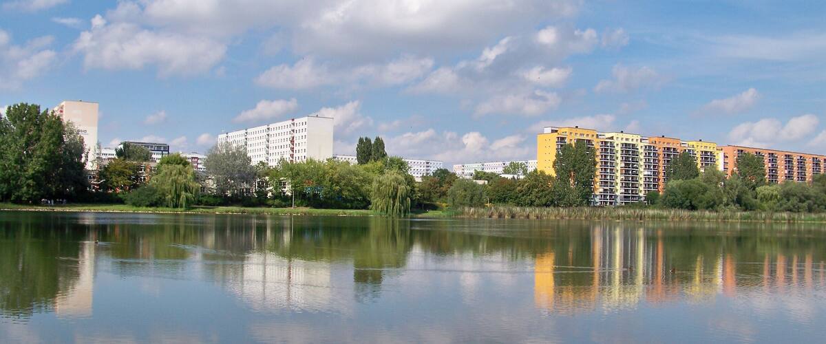 Der Silbersee in Leipzig, dahinter die Plattenbau-Silhouette des Stadtteils Lößnig im Süden der Stadt
