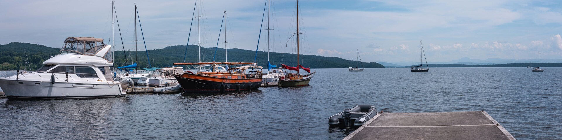 Lake Champlain summer landscape with moored boats, yachts, and walking dock in New York