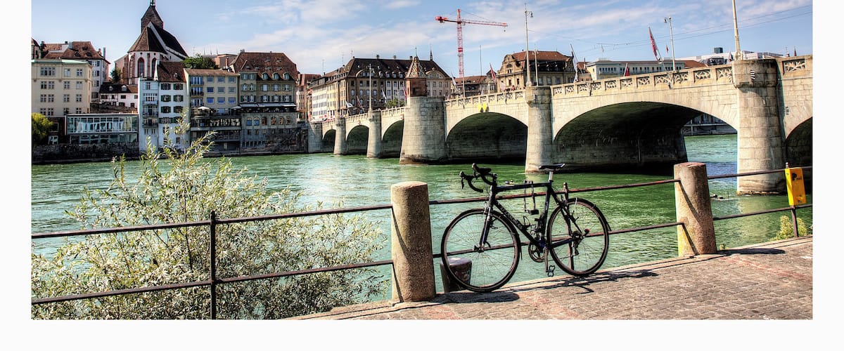 A stone bridge over a river with a bicycle parked on the side.