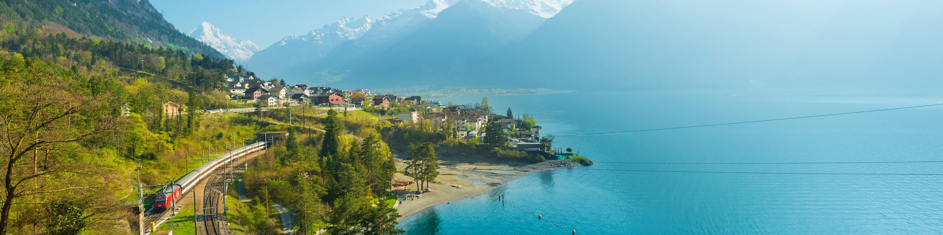 Small towns in Europe. Fluelen. Switzerland. View of the small town in the Alps mountains. Traditional houses. Railway along Lake Lucerne. Canton Uri.