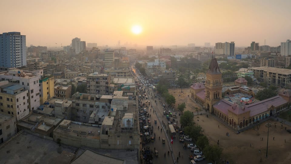 Aerial view of vibrant downtown Karachi buildings and bustling traffic at sunset, Saddar, Sindh, Pakistan.
