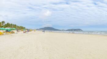 Panoramic view of the Enseada beach - Praia da Enseada - Guaruja SP Brazil. People on the beach, sunshades on the sand and the sea. Brazilian tourist destination.