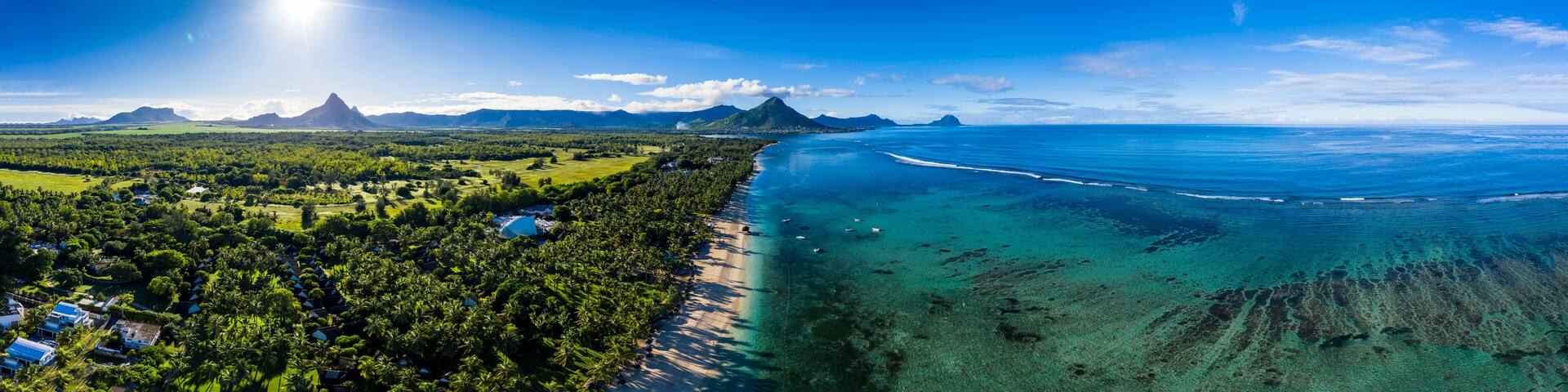 Mauritius, Black River, Flic-en-Flac, Aerial panorama of sun shining over palm trees along coastal beach in summer