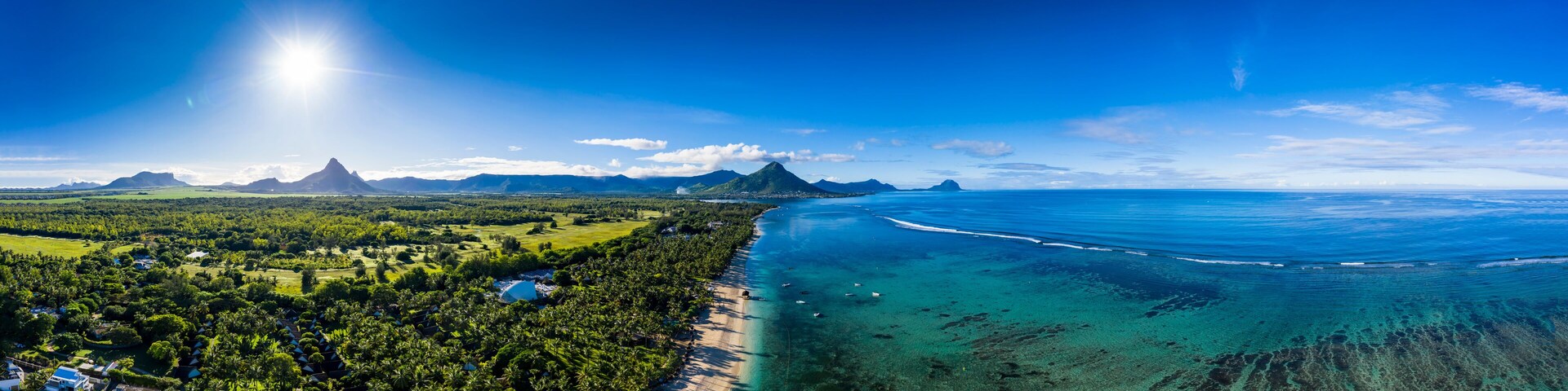 Mauritius, Black River, Flic-en-Flac, Aerial panorama of sun shining over palm trees along coastal beach in summer