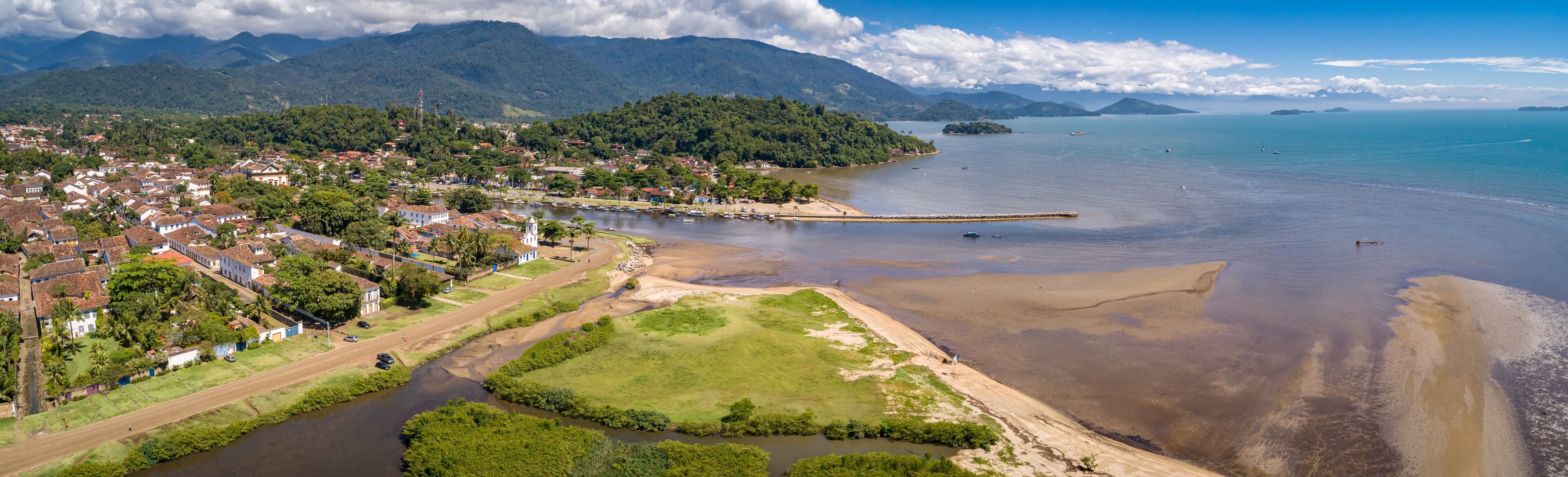 Panoramic aerial view to historic town Paraty, tidal river and Jabaquara with green mountains in background on a sunny day, Brazil, Unesco World Heritage