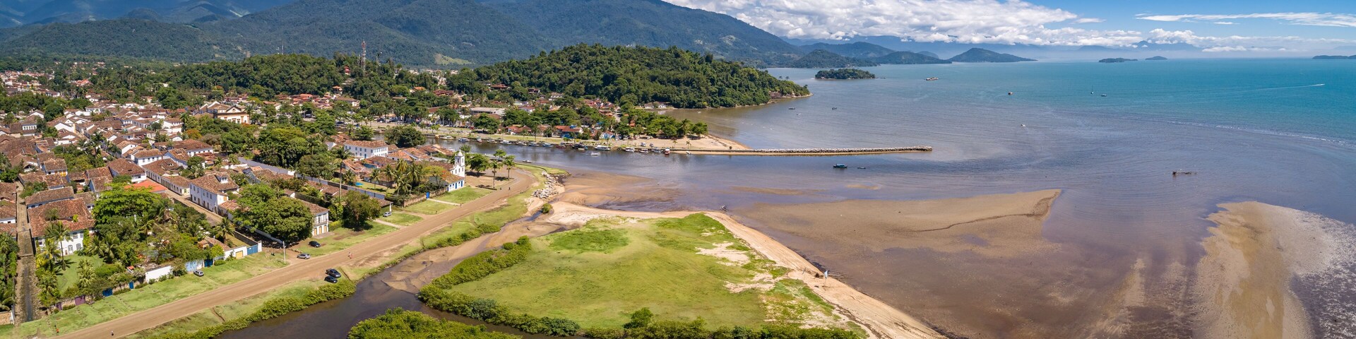 Panoramic aerial view to historic town Paraty, tidal river and Jabaquara with green mountains in background on a sunny day, Brazil, Unesco World Heritage