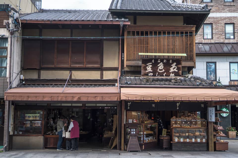 A traditional Japanese building with a wooden facade and a signboard.