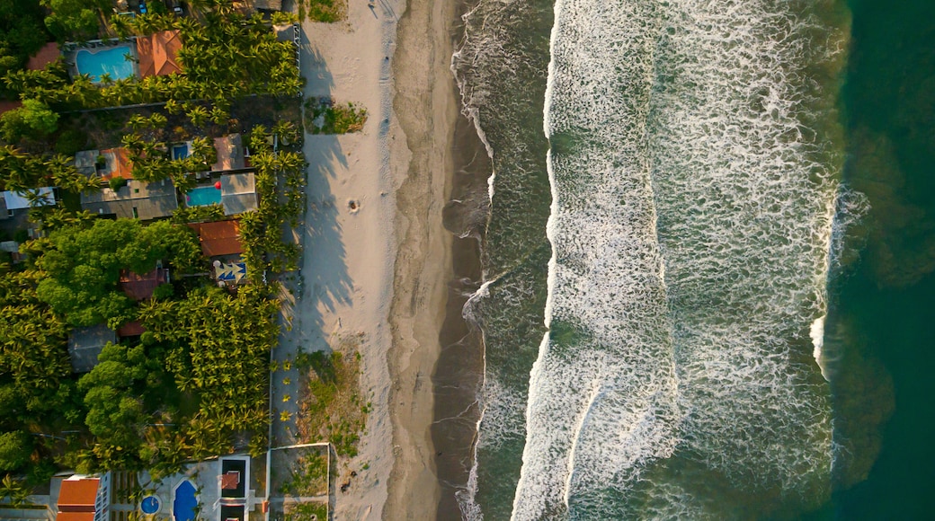 Ein Strand mit Wellen, einem Pool und HĂ€usern.