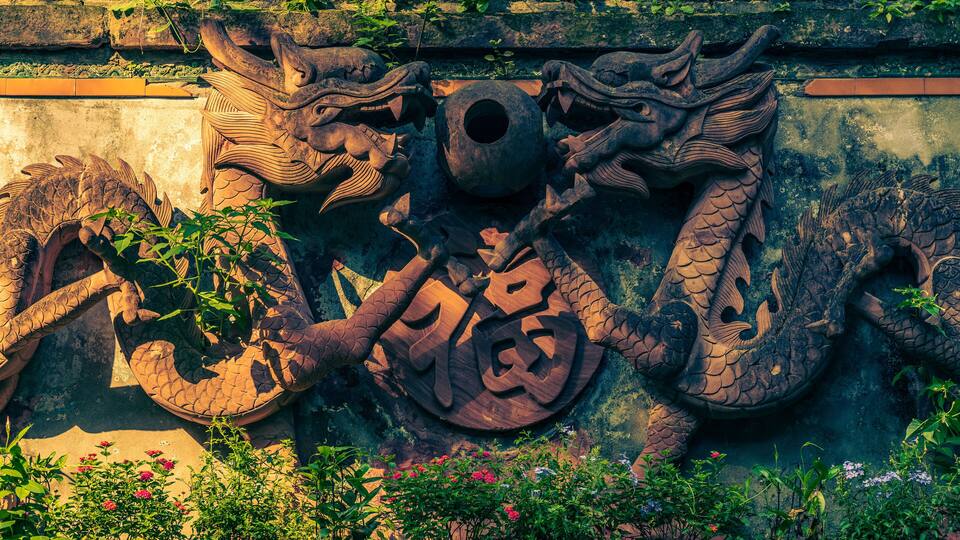 two dragon statues in the temple. The symbol in the center is a Chinese character which means "good luck".
