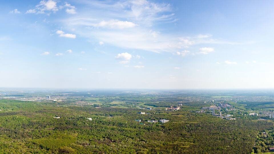 The panoramic bird's eye view shooting from drone to Holosiivskyi district with recreational area and urban infrastructure in Kiev, Ukraine at summer sunset.