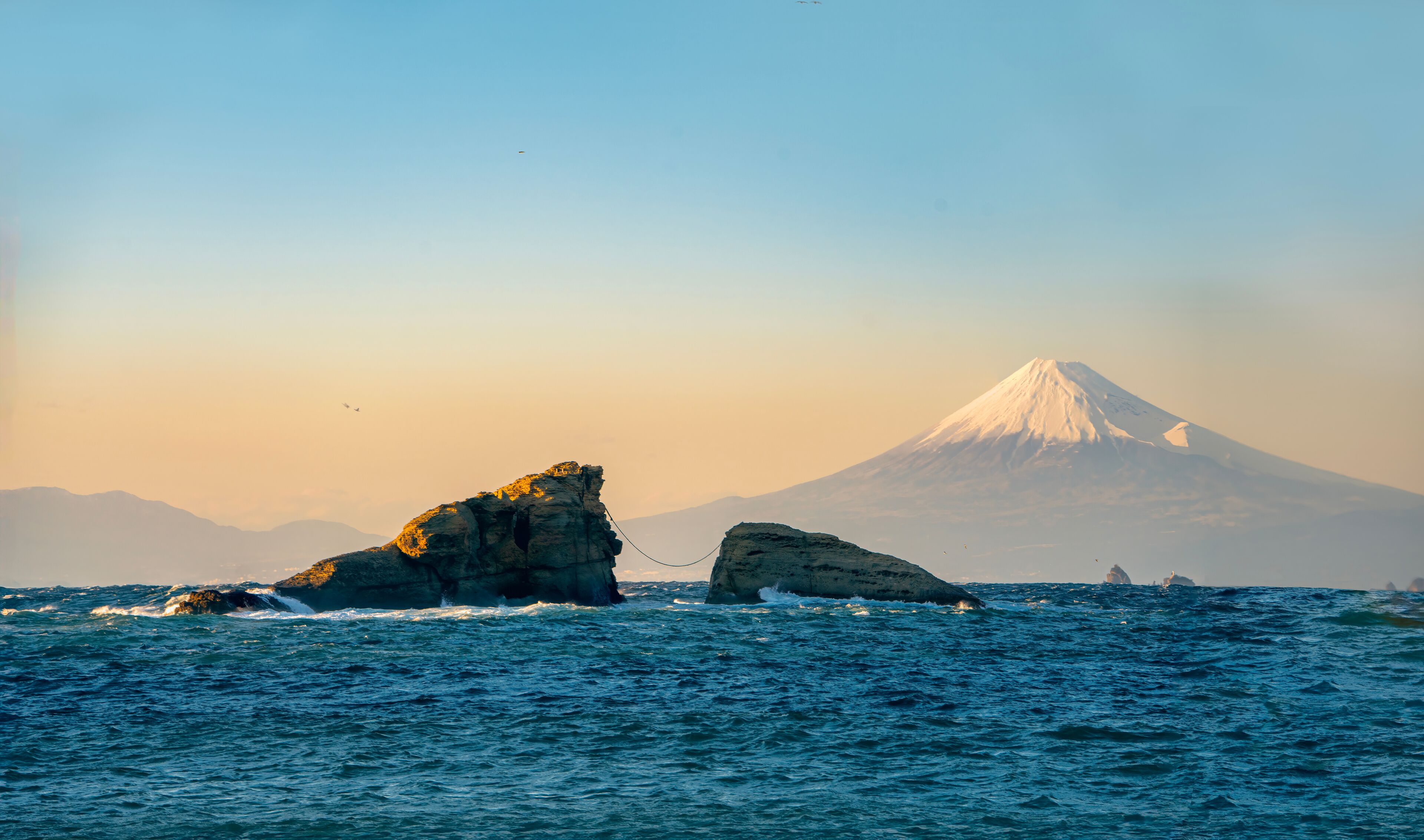 Mount Fuji Sunset View with Sacred Wedded Rocks at Kumoni Shore, Izu Peninsula, Japan. A breathtaking sunset view from Kumoni Shore on the Izu Peninsula, Japan.

