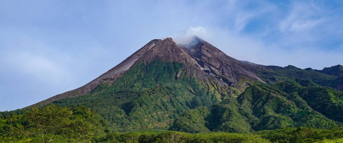 Majestic Mount Merapi Volcano Landscape with Blue Sky and Green Forest in Yogyakarta