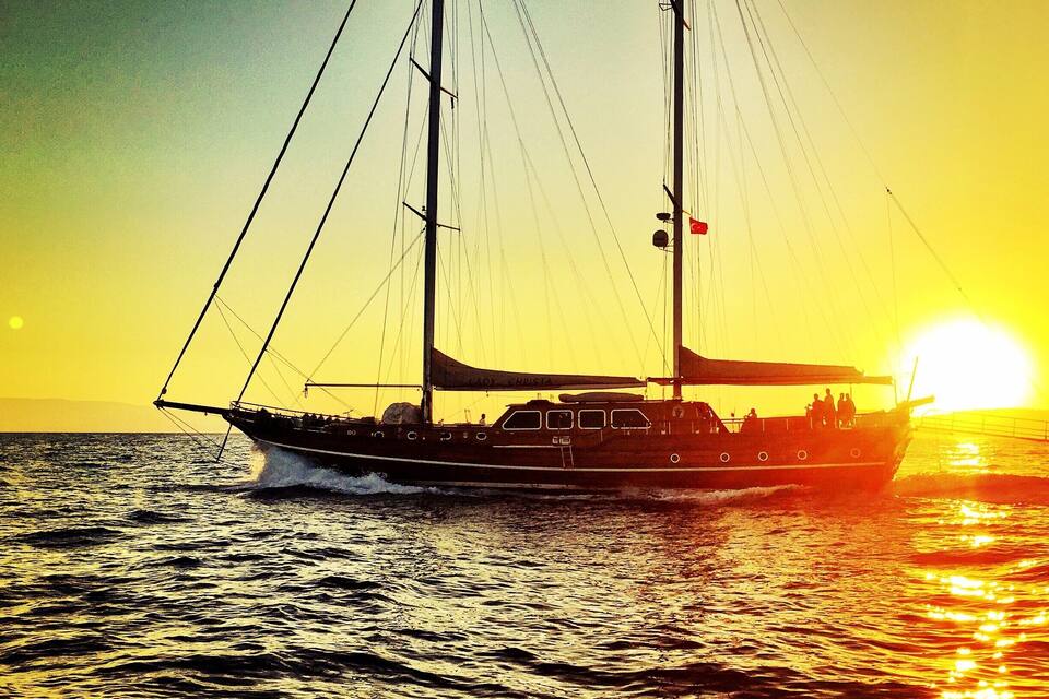 A sailboat on the ocean at sunset.