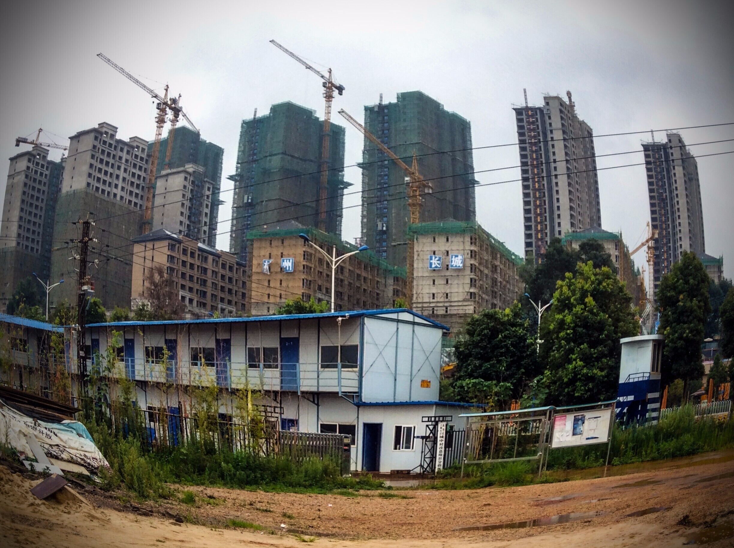 Prefab housing types 1, 2 and 3

Actually, the blue and white shacks in the foreground are the only prefab houses in the picture, but who's counting.  These houses are seen at almost every large development site as this is the housing for the migrant labourers who are doing most of the work on site.  

Once the site is completed, the workers and their houses migrate to the next site that is scheduled to be built...man what a life!