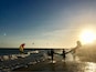 Una playa con gente caminando y volando cometas.