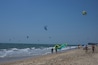 A beach with people and kites.