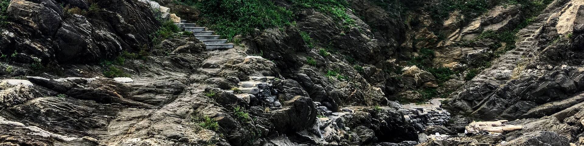Looking up from the rocky coast at the small pagoda by the sea.