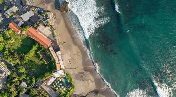 Drone aerial view of beach and buildings on the shoreline at Batu Bolong; Canggu, Bali, Indonesia