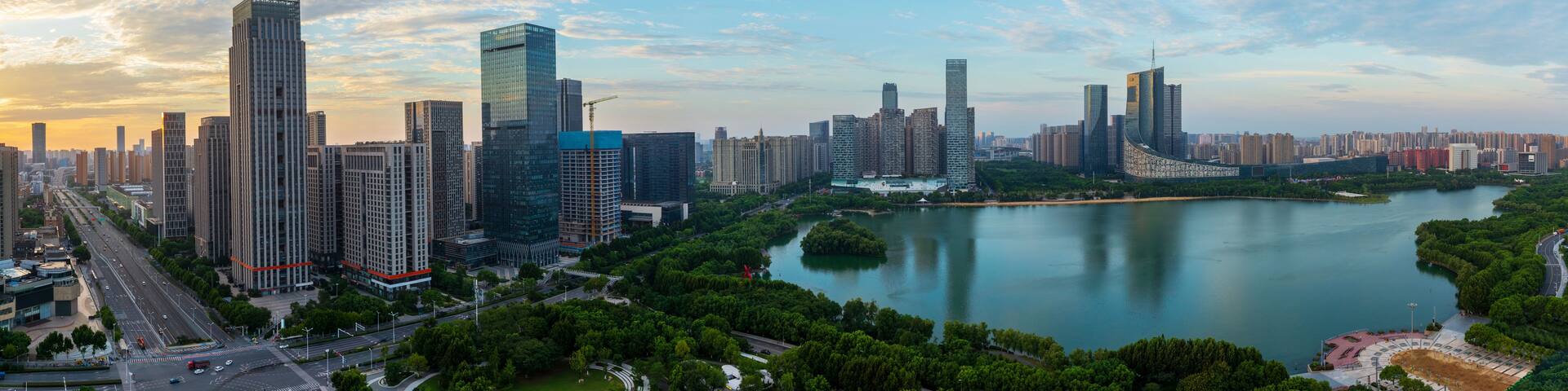A cityscape with modern skyscrapers, a river, and surrounding greenery.