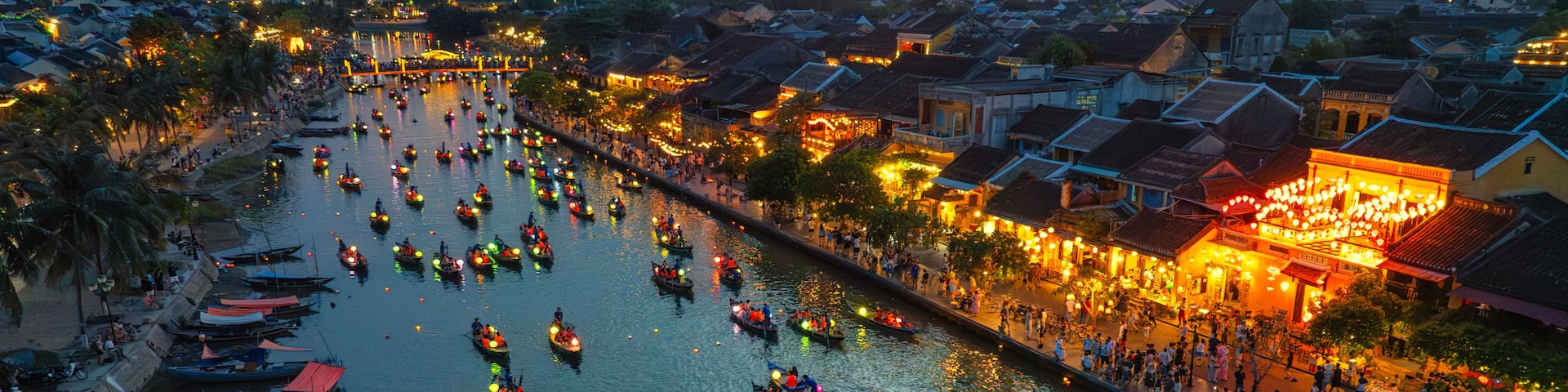 A river with boats and a cityscape at sunset.