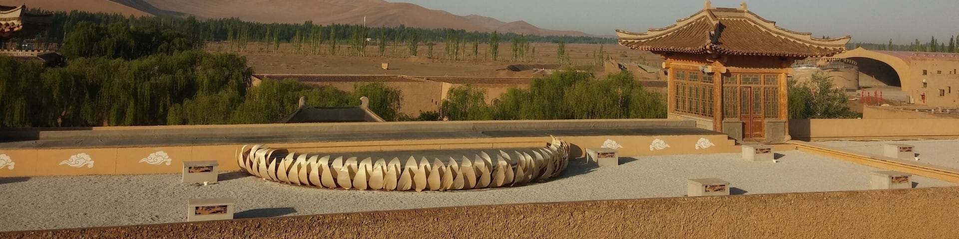 A rooftop view of the sand dunes and Gobi Desert in the distance.