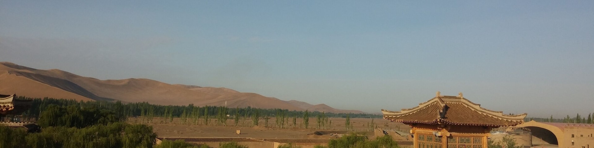 A rooftop view of the sand dunes and Gobi Desert in the distance.
