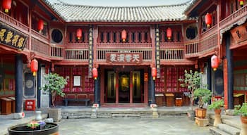 Ein traditioneller chinesischer Innenhof mit roten Laternen, Ziegeldächern und kunstvollen Holztüren.