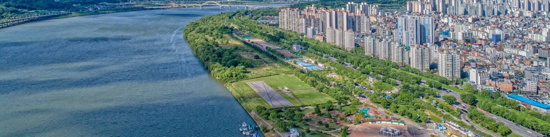 Amsa-dong, Gangdong-gu, Seoul, South Korea - May 19, 2020: Aerial view of the Amsa Dunchi Ecological Park and highrise apartments near Han River