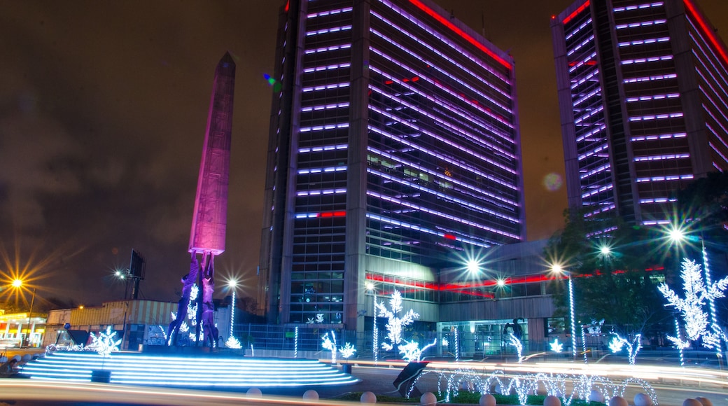 Aranha de edifícios iluminados, um obelisco imponente e luzes decorativas.