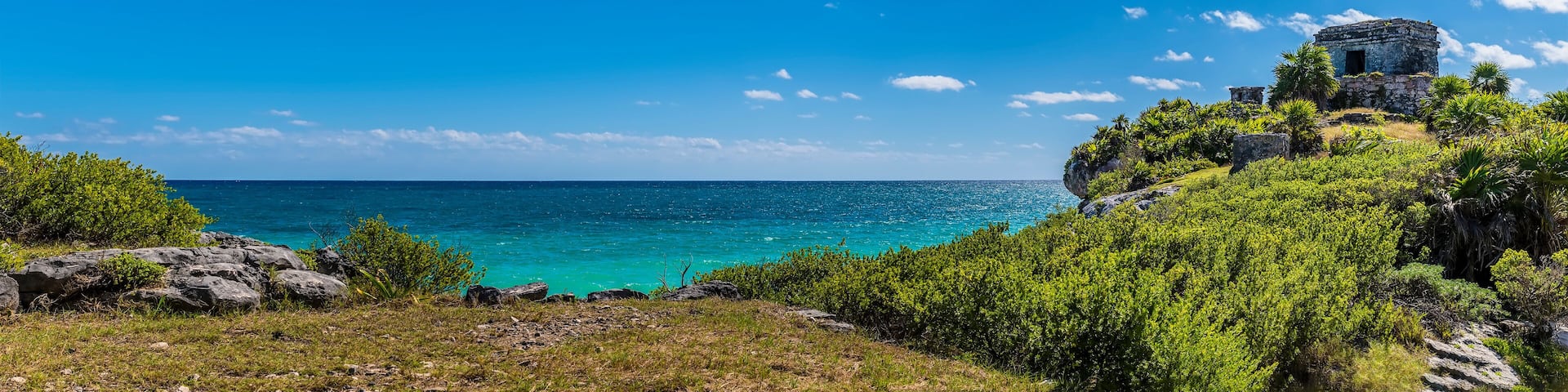 A panorama view out to sea beside the temple of the wind god at the Mayan settlement of Tulum, Mexico on a sunny day