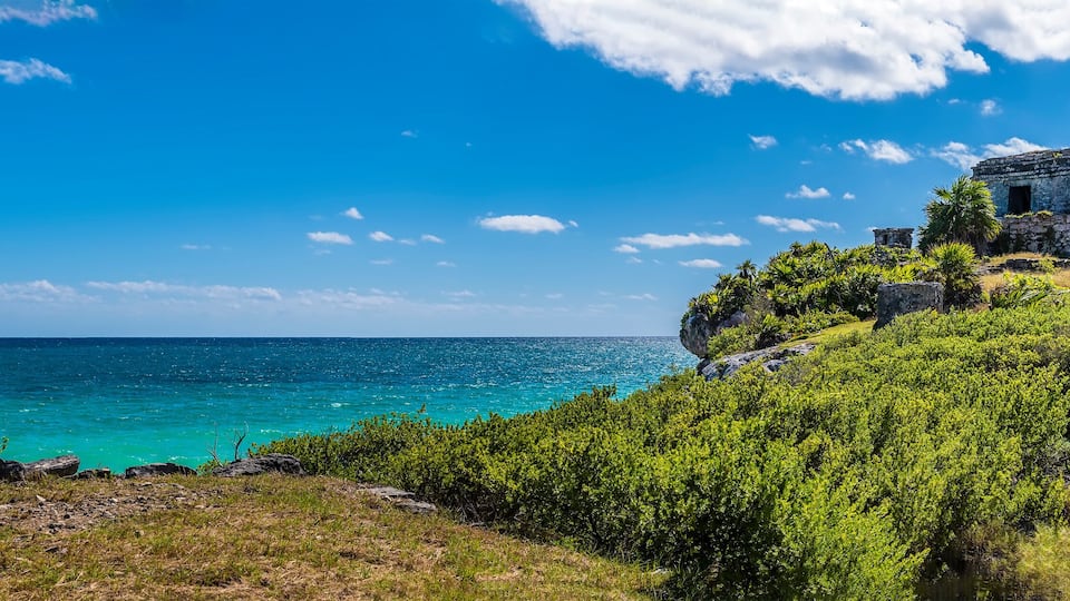 A panorama view out to sea beside the temple of the wind god at the Mayan settlement of Tulum, Mexico on a sunny day