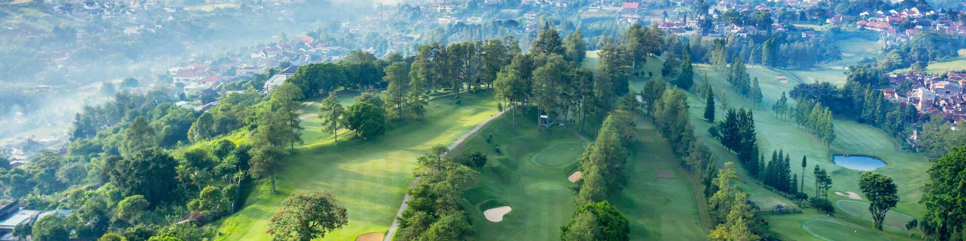 A golf course with a city in the background.