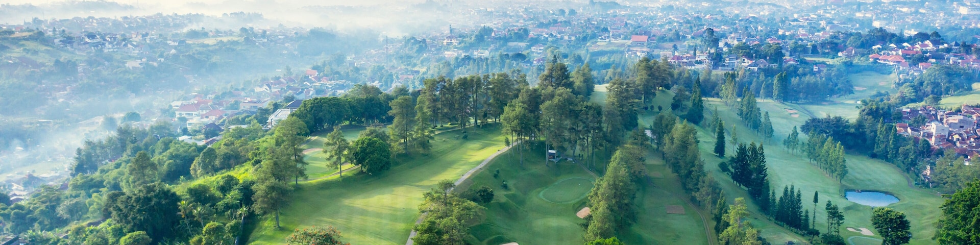 Ein Golfplatz mit einer Stadt im Hintergrund.
