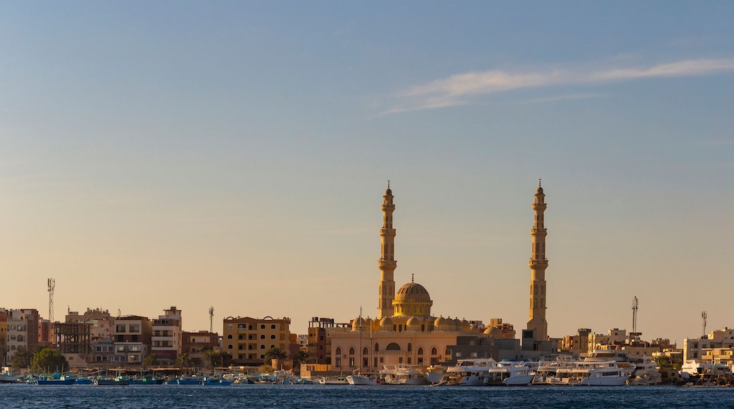Hurghada, Egypt, a city at sunset. View of the ancient city from the red sea. Panoramic view. A port with ships and a residential area with a mosque.
