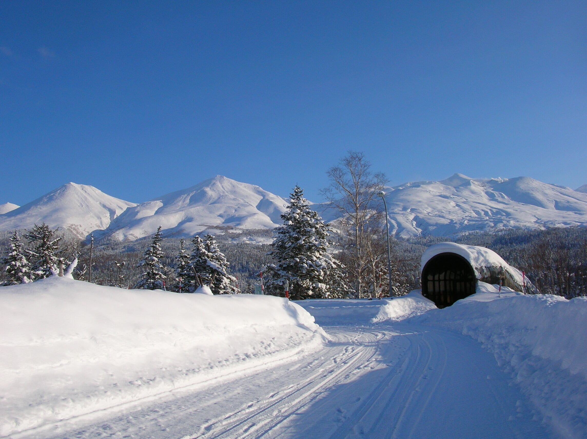 A snow-covered mountain landscape with a tunnel entrance.