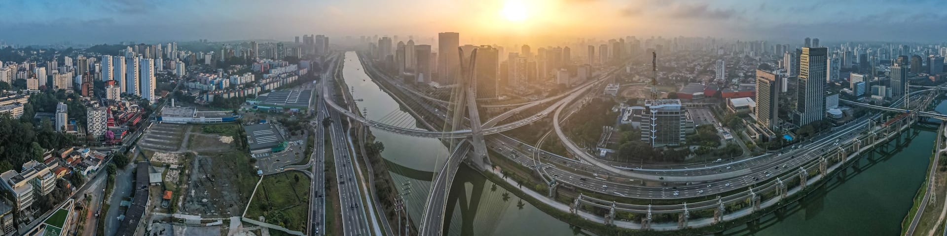 A cityscape with a river, multiple bridges, and high-rise buildings under a clear sky.