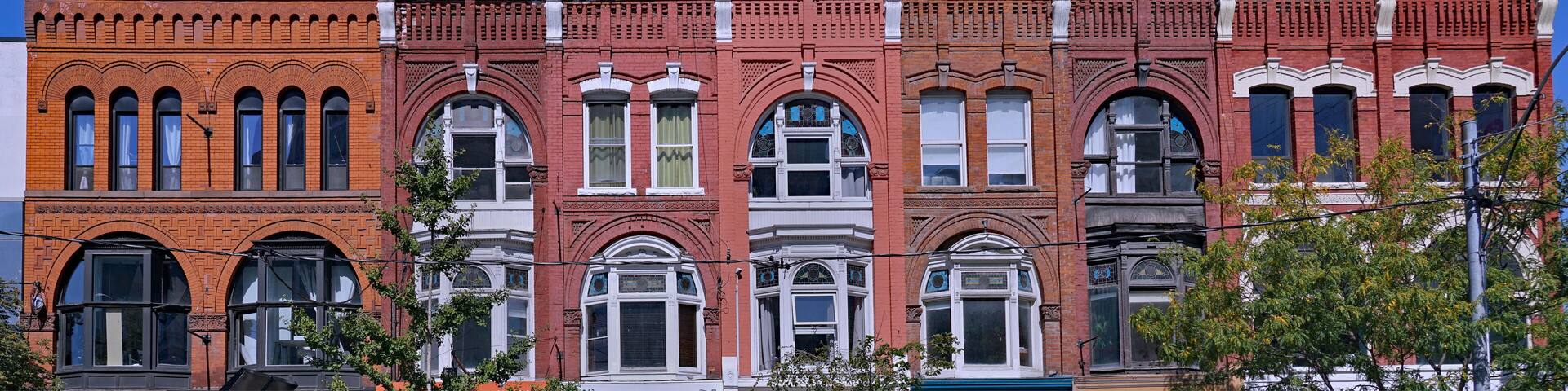 Block of ornate 19th century building facades in Toronto, Queen Street West, apartments above stores
