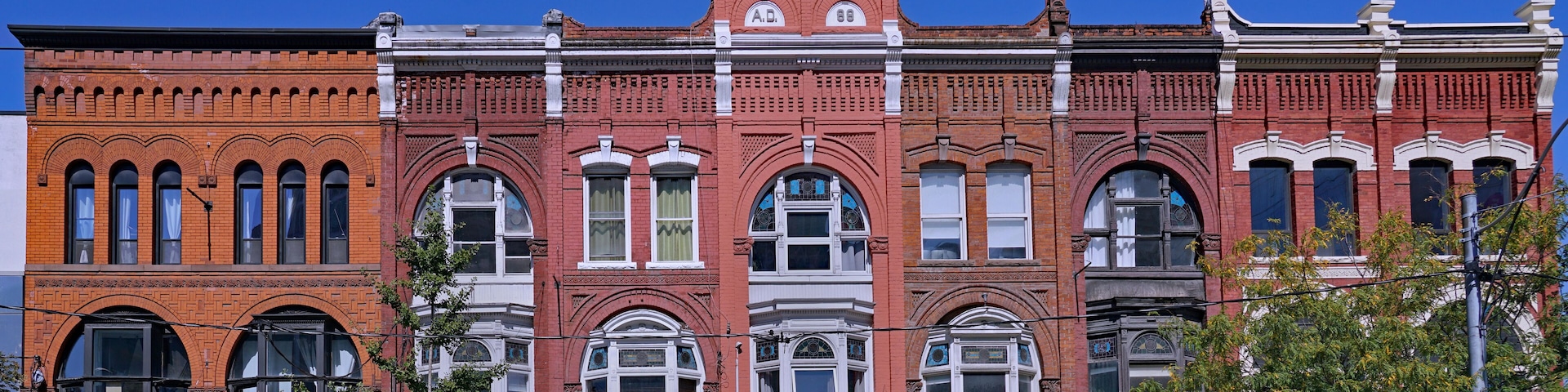 Block of ornate 19th century building facades in Toronto, Queen Street West, apartments above stores