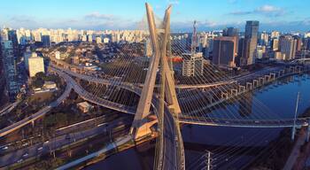 Een kabelbrug met een stadsgezicht op de achtergrond.