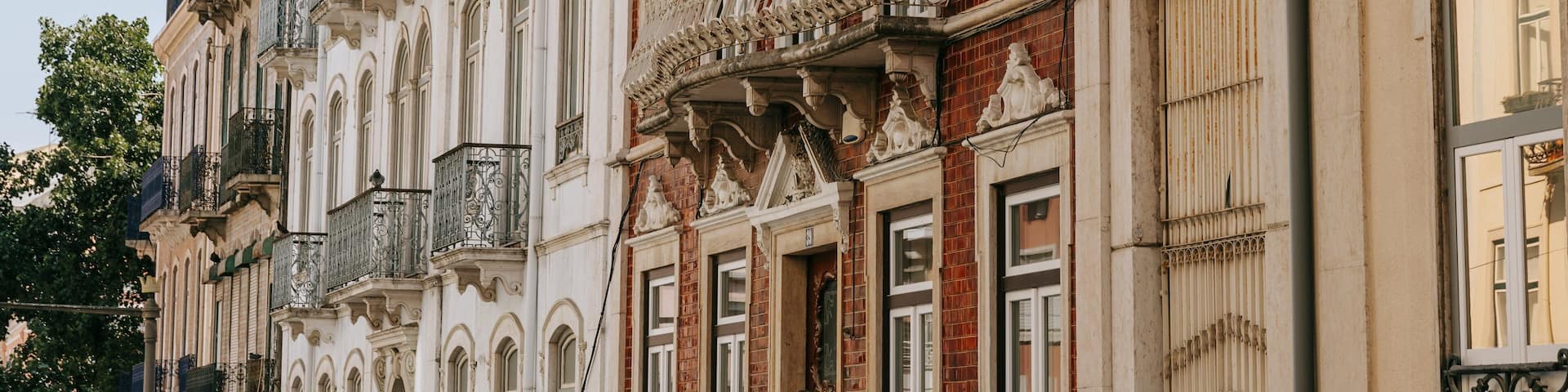 A row of historic buildings with ornate balconies and detailed facades.