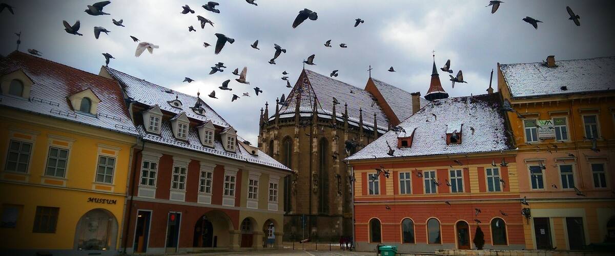A historic square with a cathedral and colorful buildings.