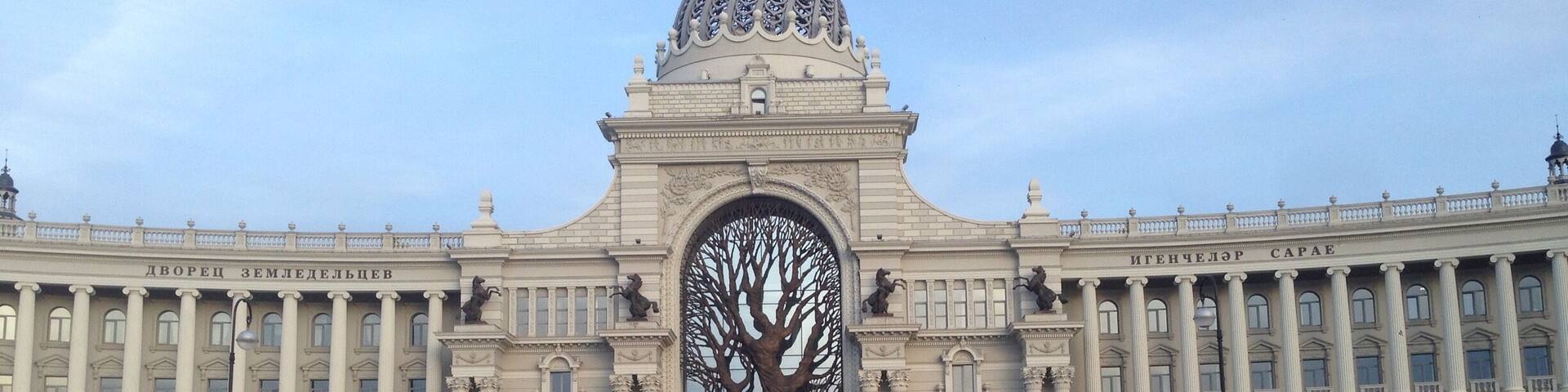 A large building with a central tree sculpture and a dome.