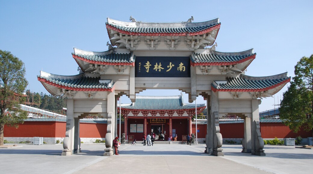 A traditional Chinese gate with ornate architecture and a clear sky.