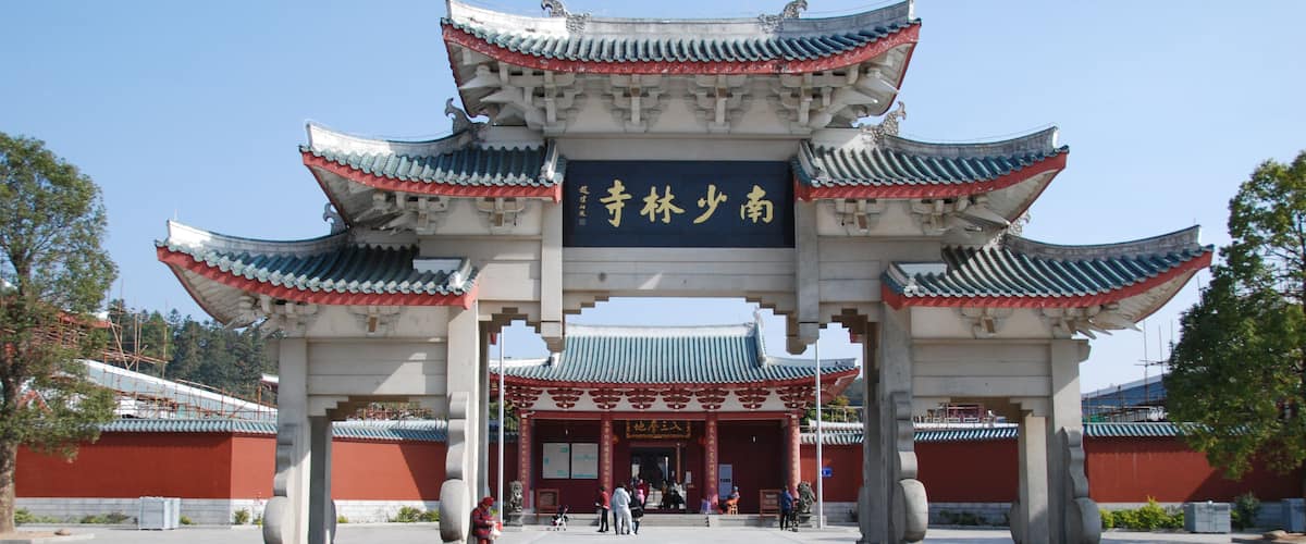 A traditional Chinese gate with ornate architecture and a clear sky.