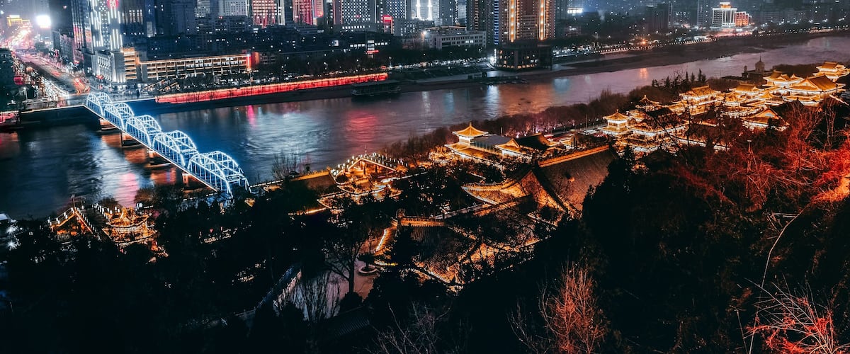 A cityscape with a river, a bridge, and traditional architecture.