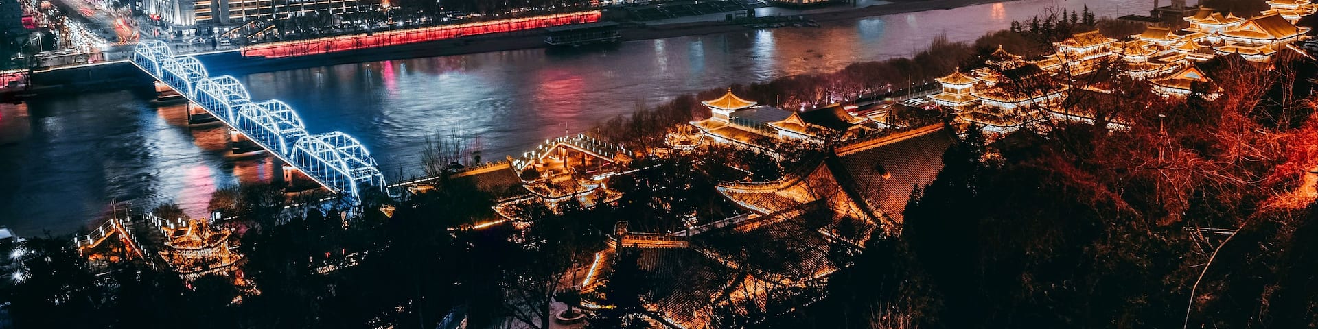A cityscape with a river, a bridge, and traditional architecture.