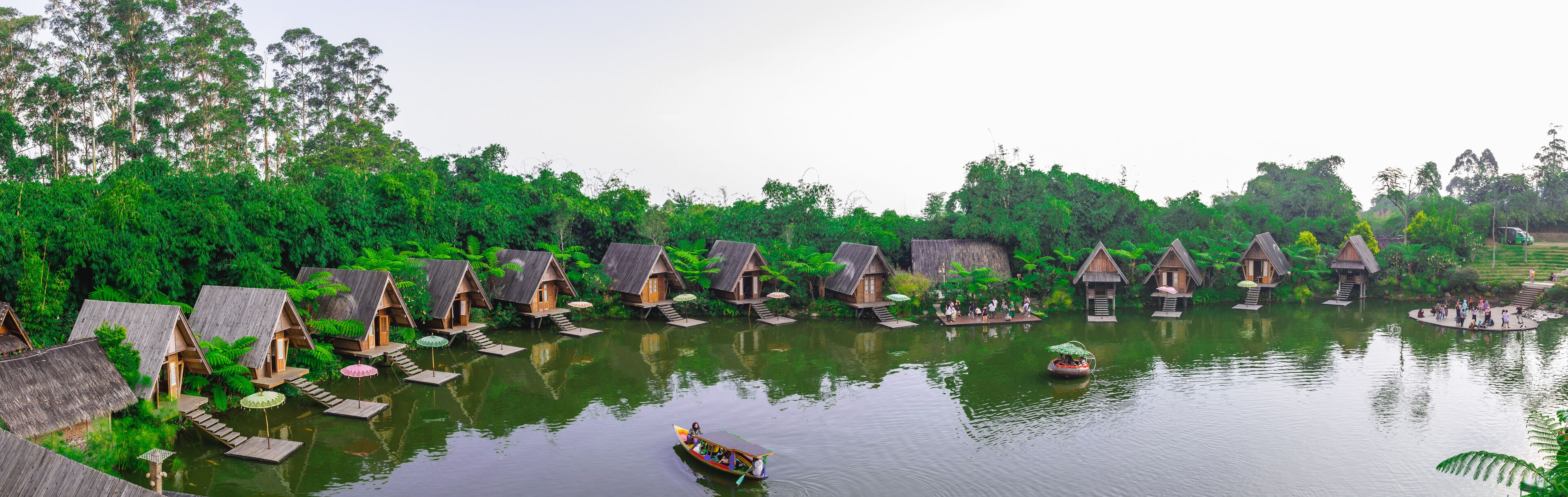 Panorama of a lake surrounded by wooden houses with boats