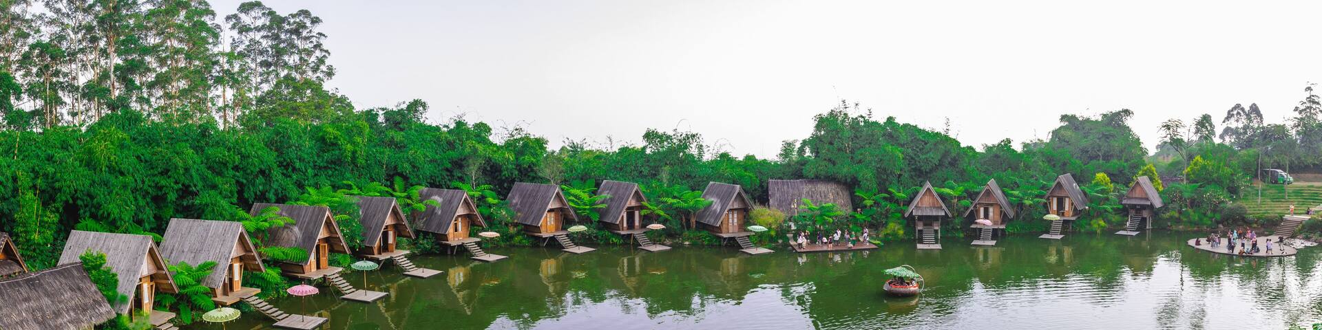 Panorama of a lake surrounded by wooden houses with boats