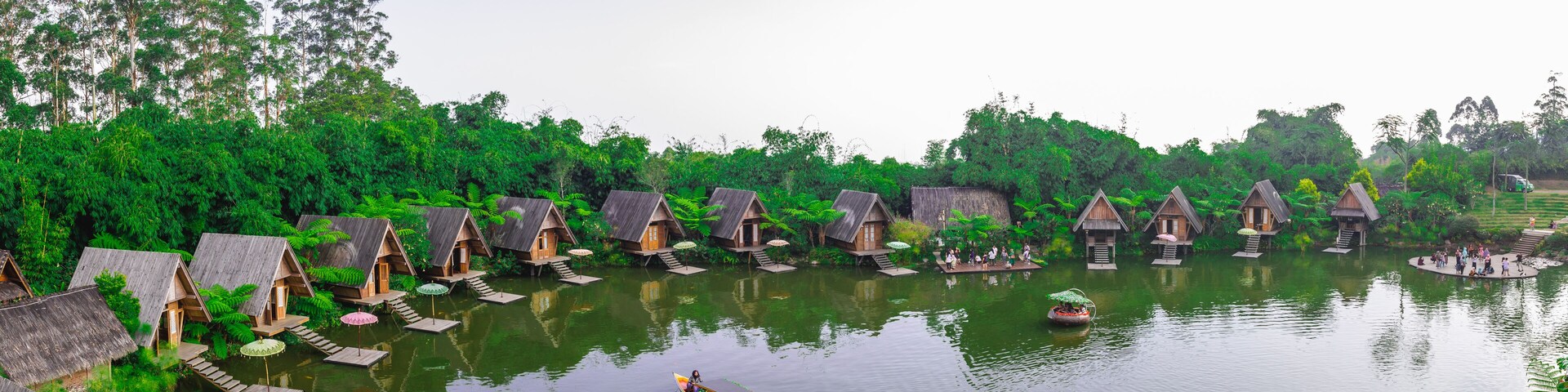 Panorama of a lake surrounded by wooden houses with boats